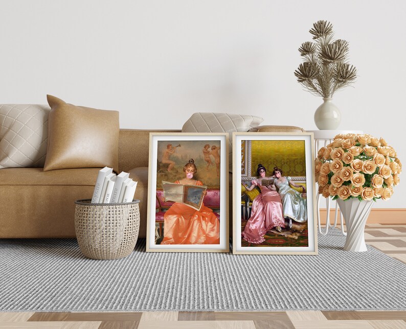 May include: Two framed paintings of women in vintage dresses. The woman in the left painting is wearing a peach dress and holding a book. The woman in the right painting is wearing a pink dress and sitting next to another woman in a white dress.