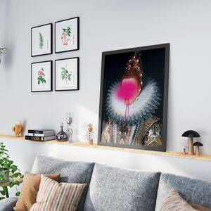 May include: A framed print of a portrait of a person wearing a white ruff collar and a gold and black patterned dress. The person's face is covered in pink spray paint.