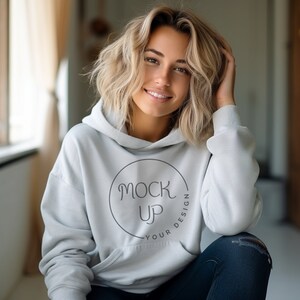 Puede incluir: Una sudadera con capucha blanca con el texto "Mock Up Your Design" en un círculo en la parte delantera.