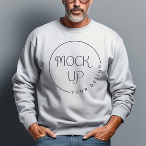 Puede incluir: Una sudadera gris con un gráfico circular que dice "Your Design Mock Up" en una fuente manuscrita.
