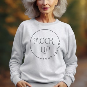 Puede incluir: Una sudadera blanca con un círculo negro y el texto "MOCK UP YOUR DESIGN" dentro del círculo.