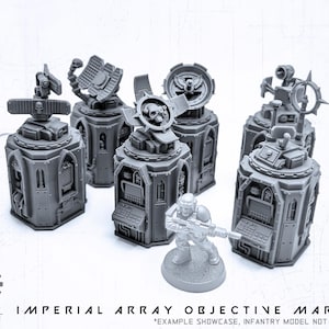 Könnte beinhalten: Graue Imperial Array Objective Marker mit verschiedenen Top-Designs, darunter Schädel und Antennen. Die Marker haben eine detaillierte, futuristische Ästhetik. Eine Miniatur-Soldatenfigur ist ebenfalls abgebildet. Der Text unten lautet "Imperial Array Objective Marker".