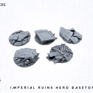 Puede incluir: Cinco bases de héroe Imperial Ruins grises. Cada base presenta escombros en miniatura detallados, incluyendo piedras rotas, calaveras y fragmentos arquitectónicos. Las bases son circulares y están diseñadas para juegos de mesa.