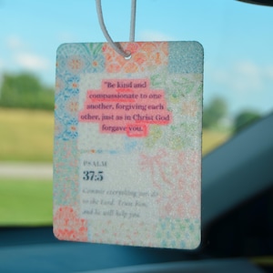 May include: Rectangular car air freshener with a floral design and the text "Be kind and compassionate to one another, forgiving each other, just as in Christ God forgave you." Psalm 37:5.