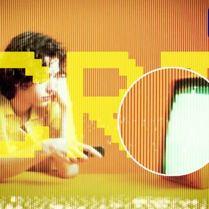 May include: A person sits in front of a television screen with a yellow and orange pixelated pattern. The screen is displaying the text "GET" in yellow. The person is holding a remote control. The television screen is surrounded by a black frame.