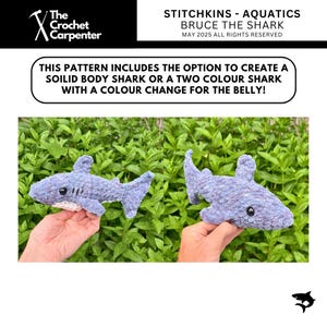 K&ouml;nnte beinhalten: Zwei geh&auml;kelte Hai-Spielzeuge in Blau- und Graut&ouml;nen werden vor einem Hintergrund aus gr&uuml;nem Laub gehalten. Die Haie haben schwarze Augen und wei&szlig;e B&auml;uche. Der Text auf dem Bild lautet "STITCHKINS - AQUATICS BRUCE THE SHARK".