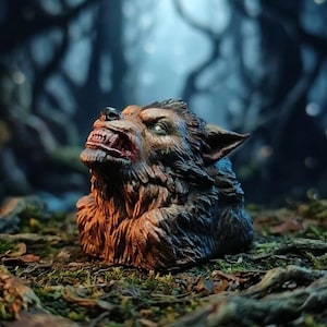 May include: A detailed figurine of a snarling werewolf head with textured brown and black fur, pointed ears, and bared teeth. The creature is depicted with its head tilted upward, showcasing intricate facial features and a menacing expression.