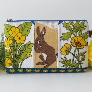 Borsa per il trucco patchwork con timida lepre bruna selvatica, coniglietto divertente, fiori di campo, primula, ranuncolo, cuori atomici, regali unici per lei