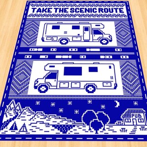 K&ouml;nnte beinhalten: Blau-wei&szlig;er Pixel-Art-Teppich mit dem Text "TAKE THE SCENIC ROUTE" und zwei Bildern eines wei&szlig;en Wohnmobils. Der untere Teil des Teppichs zeigt eine Pixel-Art-Szene mit einer Bergkette, B&auml;umen, einem Zelt, einem Mond und einem Geb&auml;ude mit dem Text "PUB".