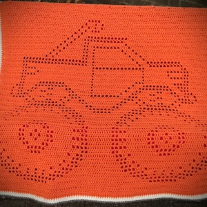 May include: A crocheted blanket in a bright orange colour with a white and grey border. The blanket features a repeating pattern of circles.