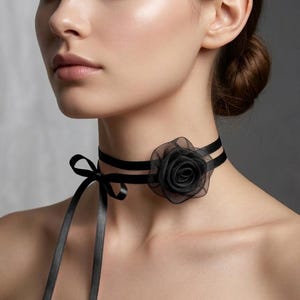 Puede incluir: Elegante gargantilla negra con un diseño de doble banda y un detalle de rosa negra. La gargantilla tiene un lazo de cinta de satén para un ajuste ajustable, ofreciendo un aspecto clásico y elegante.