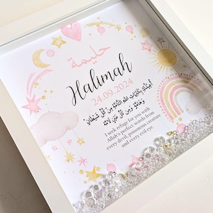 May include: A white frame with a pink and gold design. The frame contains a printed image with the name "Halimah" and the date "24.09.2024". The image also includes a rainbow, stars, and clouds. The frame is filled with clear crystals.