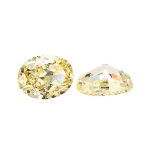 May include: Two yellow oval-shaped gemstones, one viewed from the top and the other from the side.