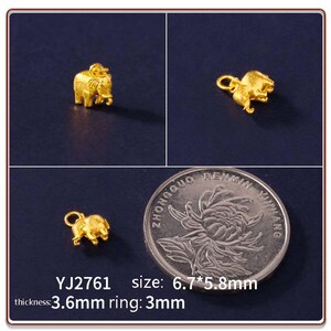 Op de afbeelding: Gouden olifantenbedel met een ringbevestiging. De bedel is 6,7 x 5,8 mm groot, 3,6 mm dik en de ring is 3 mm. De afbeelding bevat ook een munt en de tekst "YJ2761 size: 6.7*5.8mm thickness: 3.6mm ring: 3mm."