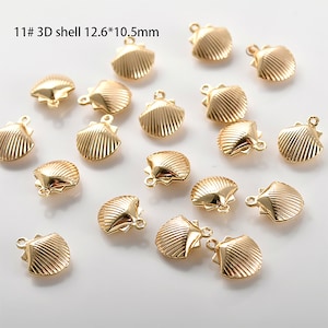 May include: 11 gold-coloured 3D shell charms, each measuring 12.6 x 10.5 mm. The charms have a detailed shell design and a loop for attaching to jewellery or crafts.