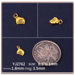 Op de afbeelding: Goudkleurige kamvormige hanger met een lus om aan een ketting te bevestigen. De hanger wordt in meerdere weergaven getoond, met de afmetingen van 6,5 mm x 6,1 mm, 1,8 mm dikte en een ringmaat van 3,5 mm. De tekst "YJ2762" is ook zichtbaar.
