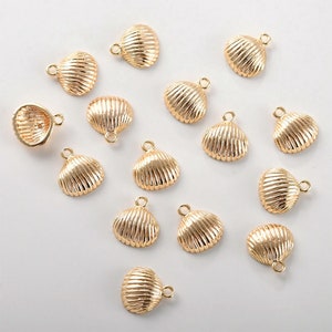 May include: A collection of 16 gold-coloured seashell charms with a loop for attaching to jewellery or other crafts.