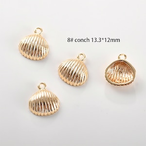 May include: Four gold-coloured seashell charms with a hole for attaching to jewellery. Each charm is approximately 1.3 cm by 1.2 cm.