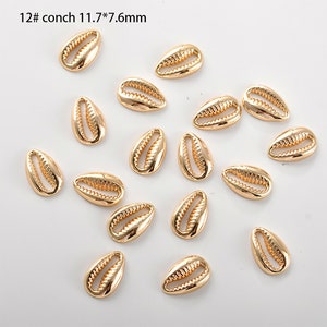 May include: A collection of 18 gold-coloured seashell charms, each measuring 11.7 mm by 7.6 mm. The charms are arranged on a white background.