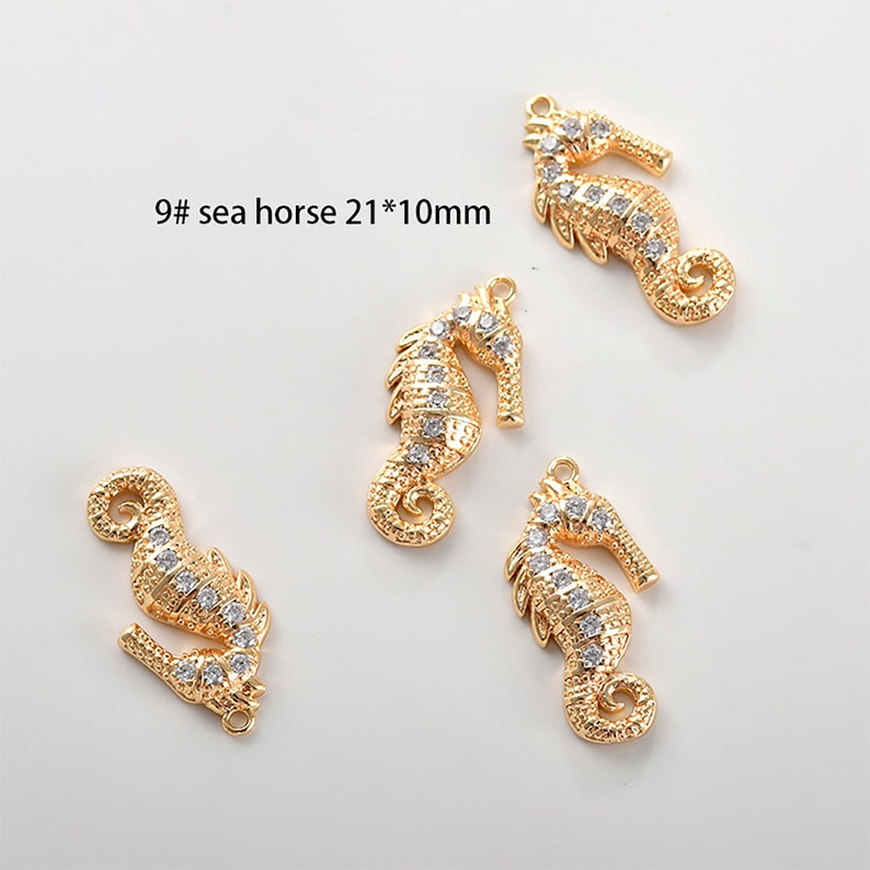 May include: Four gold-tone seahorse charms with clear rhinestone accents. Each charm measures approximately 2.1 cm by 1 cm.