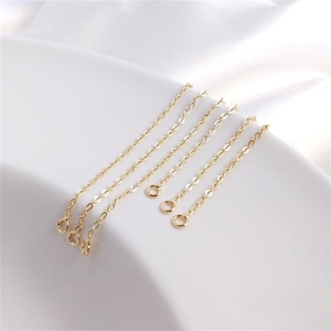 May include: A set of five gold-toned metal chains, each featuring a series of small, uniform oval links. Each individual chain segment is finished with a small, circular jump ring at one end, designed for jewelry assembly and attachment.
