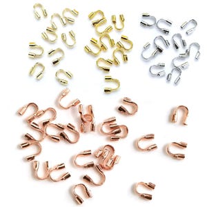 Peut inclure: Divers assortiments de connecteurs de sertissage de bijoux en or, argent et or rose. Ces petites pièces métalliques en forme de U sont utilisées en bijouterie pour fixer les extrémités des cordons ou des chaînes.