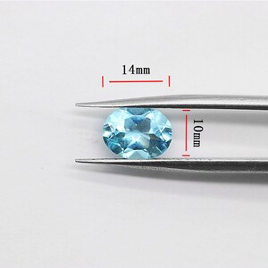 May include: A light blue oval gemstone measuring 14mm in length and 10mm in width.