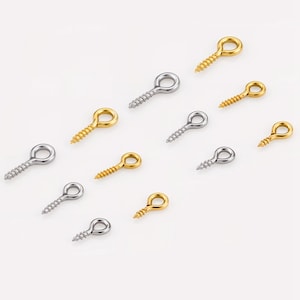 May include: A collection of small eye screw hooks in gold and silver. The hooks feature a loop at the top and a threaded screw base. Suitable for jewellery making, crafts, and various DIY projects.