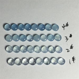 以下が含まれることがあります： 薄い青色の丸い宝石が4列あり、各列には1から4までの番号が付けられています。