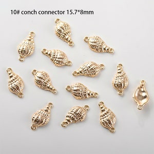 May include: Ten gold-coloured conch shell connector charms with a loop on each end. The charms are approximately 1.57 cm by 0.8 cm.