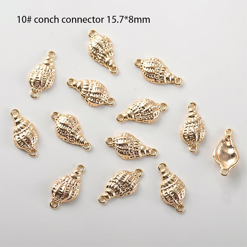 May include: Ten gold-coloured conch shell connector charms with a loop on each end. The charms are approximately 1.57 cm by 0.8 cm.
