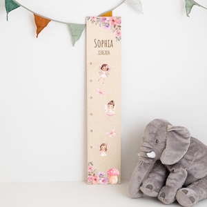 May include: A wooden growth chart with a floral design and fairy illustrations. The chart is personalized with the name "Sophia" and the date "22.06.2024".