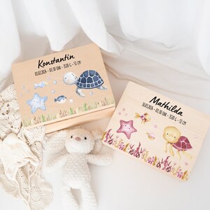 Pode incluir: Duas caixas de madeira para lembranças com desenhos de tartarugas marinhas e estrelas do mar. As caixas são personalizadas com os nomes Konstantin e Mathilda, juntamente com as datas de nascimento e as medidas. As caixas são perfeitas para guardar lembranças de bebê.