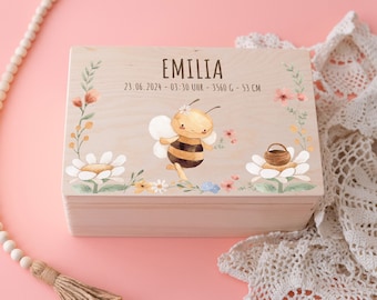 May include: Wooden keepsake box with a bee and floral design. The box is personalized with the name "Emilia" and the date "23.06.2024 - 03:30 Uhr - 3560 G - 53 CM".