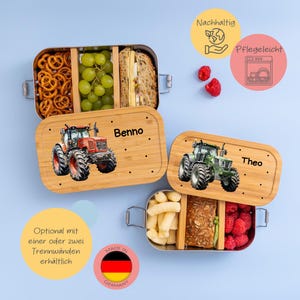 Pode incluir: Duas lancheiras de aço inoxidável com tampas de bambu. As tampas apresentam um design de trator e os nomes "Benno" e "Theo". As lancheiras são feitas na Alemanha e são opcionais com um ou dois divisores.