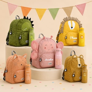 Könnte beinhalten: Eine Sammlung von fünf tierisch gestalteten Rucksäcken und passenden Trinkflaschen in Grün, Gelb, Rosa, Orange und Senfgelb. Jeder Rucksack hat eine Vordertasche mit Namensschild und die Flaschen sind mit entsprechenden Tiermotiven bedruckt.