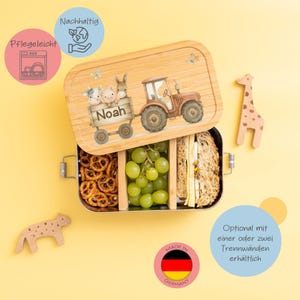 Könnte beinhalten: Eine Lunchbox aus Holz mit einer niedlichen Farm-Szene mit einem Traktor, einer Kuh, einem Schwein und einem Pferd. Die Lunchbox ist mit dem Namen "Noah" personalisiert. Die Lunchbox ist in Deutschland hergestellt und mit optionalen Trennwänden erhältlich.