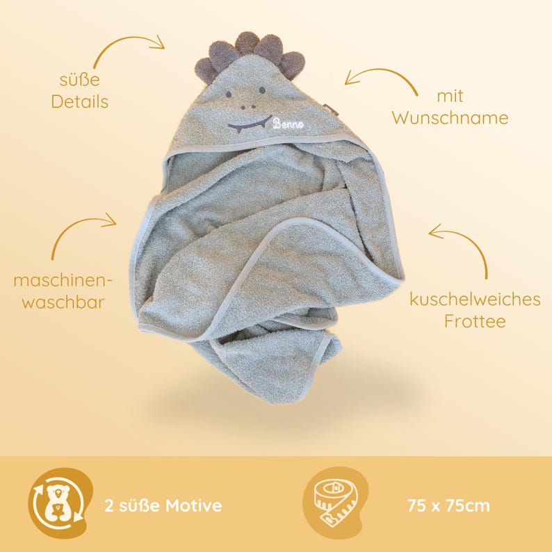 May include: A gray hooded towel with a dinosaur design. The towel is made of soft, plush fabric and has a personalized name embroidered on the hood. The towel measures 75 inches by 75 inches.