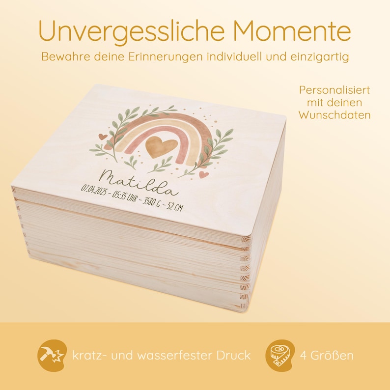 May include: A wooden keepsake box with a watercolor rainbow design, a heart, and the name Matilda. The box is personalized with the date, time, and measurements. The text "Unvergessliche Momente" is at the top of the image. The text "Personalisiert mit deinen Wunschdaten" is on the right side of the image. The text "kratz- und wasserfester Druck" is at the bottom left of the image. The text "4 Gr&ouml;&szlig;en" is at the bottom right of the image.
