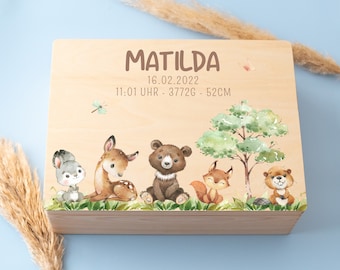 May include: Wooden keepsake box with a light wood finish. The box has a painted design of woodland animals including a deer, rabbit, bear, squirrel, and beaver. The box is decorated with the name Matilda, the date 16.02.2022, the time 11:01 Uhr, the weight 3772g, and the length 52cm.