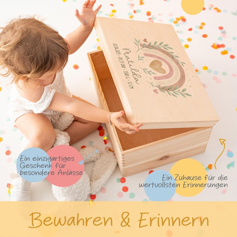May include: A wooden keepsake box with a rainbow and floral design. The box is personalized with the name "Matilda" and the date "01.04.2025 - 05:35 UR - 35806 - 52CM". The box is open and a child is reaching inside. The text "Ein einzigartiges Geschenk f&uuml;r besondere Anl&auml;sse" is on the left side of the image and "Ein Zuhause f&uuml;r die wertvollsten Erinnerungen" is on the right side of the image. The text "Bewahren & Erinnern" is at the bottom of the image.