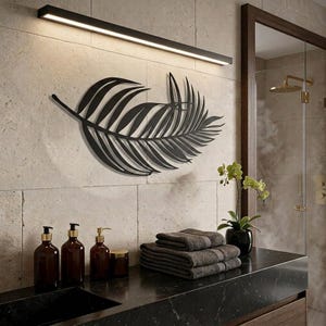 Può includere: Un'opera d'arte da parete in metallo nero a forma di grande foglia di palma, montata su una parete in pietra chiara. Il design presenta fronde sottili e complesse che si estendono da uno stelo centrale, creando una silhouette dettagliata.