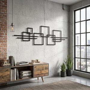 Pode incluir: Arte de parede em metal preto com um design geométrico abstrato de quadrados e linhas interligadas. A obra de arte está montada numa parede de betão acima de um armário de madeira. A sala também inclui uma janela grande, plantas e um tapete.