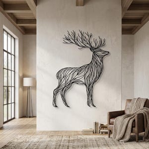 May include: A large, black metal deer wall art piece. The deer is depicted in a stylized, linear design, with intricate lines forming its body and antlers. The artwork is mounted on a neutral-colored wall in a modern living space.