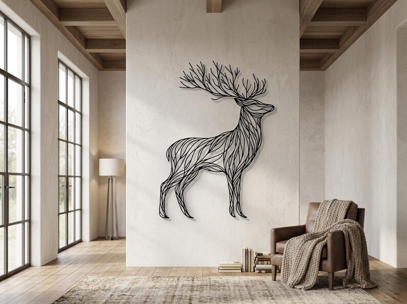 May include: A large, black metal deer wall art piece. The deer is depicted in a stylized, linear design, with intricate lines forming its body and antlers. The artwork is mounted on a neutral-colored wall in a modern living space.