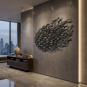 May include: A large black metal wall sculpture depicting a dense school of fish swimming in a unified direction. The artwork features intricate, flowing wire-like silhouettes of numerous fish arranged in an oval formation on a gray wall.