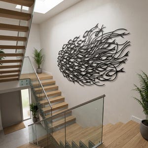 May include: A large, black, laser-cut metal wall art piece depicting a dense school of fish swimming in a fluid, directional formation. The design features numerous individual fish silhouettes integrated with flowing, wave-like lines.