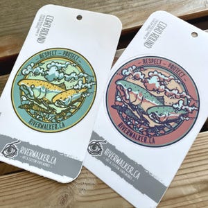 Könnte beinhalten: Zwei runde Aufkleber mit einem Lachs-Design. Die Aufkleber befinden sich auf weißem Hintergrund und tragen den Text "COHO ROUND" und "RESPECT - PROTECT". Der Text "RIVERWALKER.CA" ist ebenfalls auf den Aufklebern zu sehen.