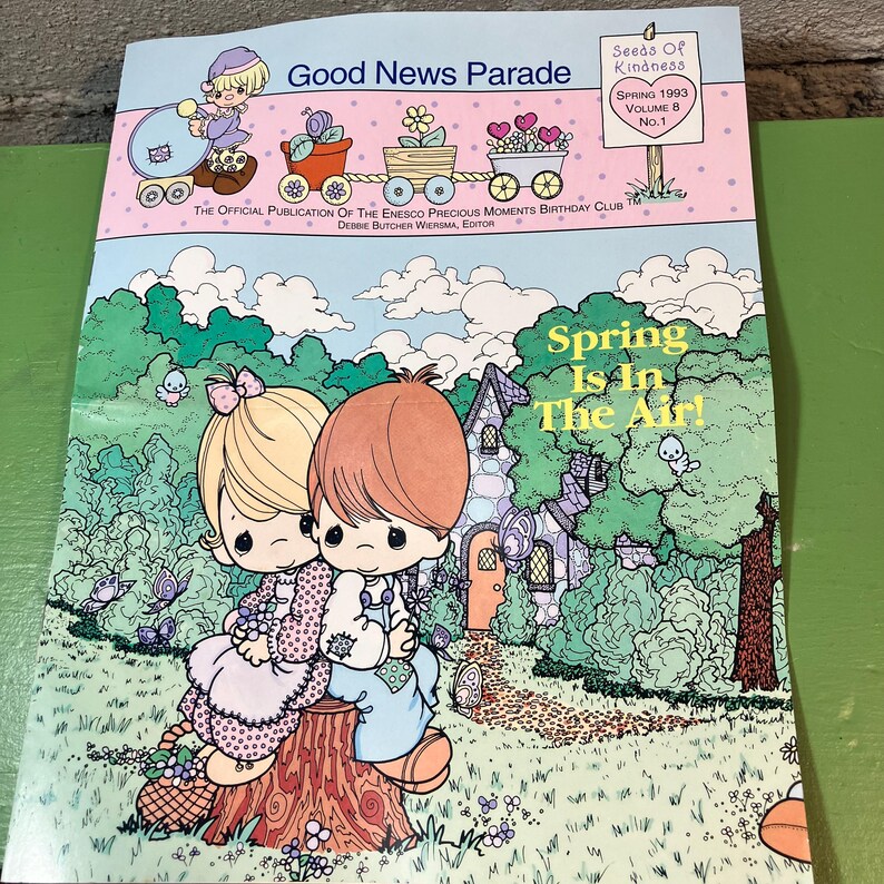 May include: A vintage "Good News Parade" magazine cover with the text "Spring Is In The Air!" features cartoon illustrations of children and a whimsical landscape. The cover includes the text "Seeds of Kindness" and "Spring 1993 Volume 8 No. 1".