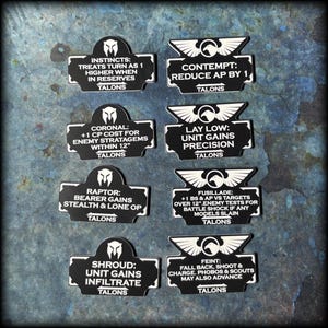 May include: A set of black and white game tokens, each with a unique description and the word "TALONS." The tokens feature a stylized emblem and are designed for a tabletop game. Phrases include "INSTINCTS" and "CONTEMPT."